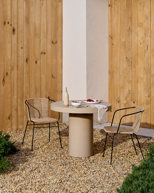 Eltiera stackable chair in synthetic rattan with black steel frame and armrests
